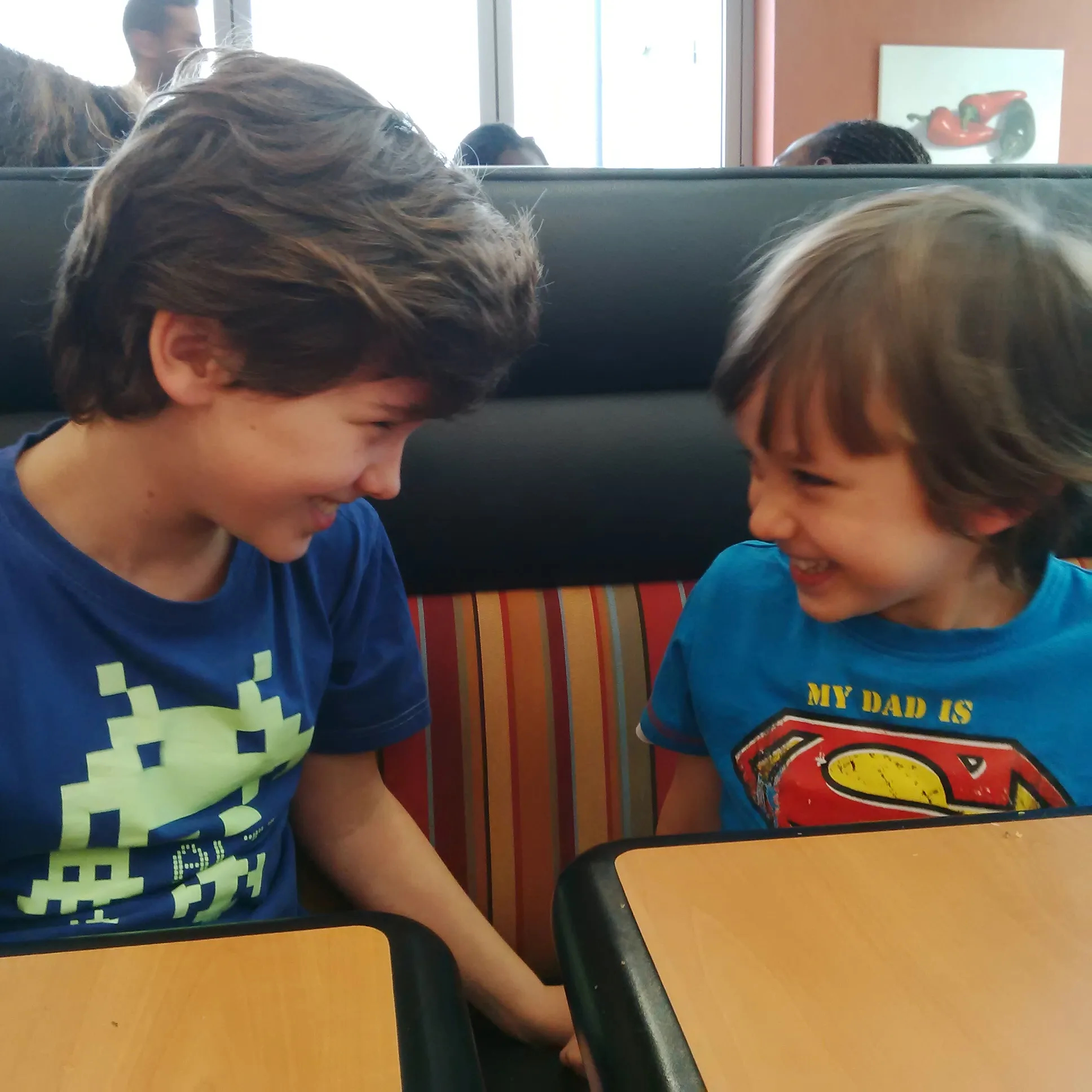 Two children at a restaurant — the expat family behind the invisible partner